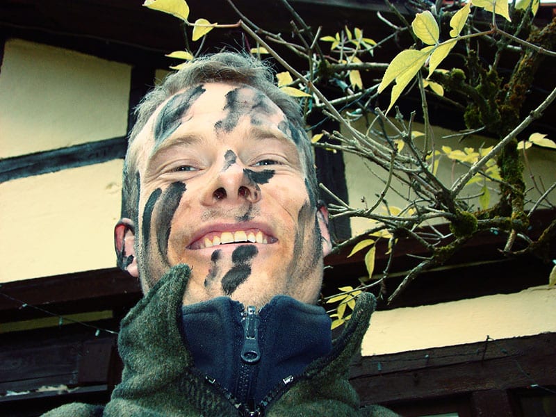 Survivaltrainer Heiko Gärtner mit Kohlestaub im Gesicht als Tarnung