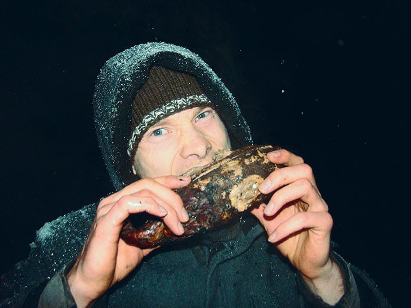 Survivalexperte Heiko Gärtner isst eine gebratene Ente als Wildnahrung