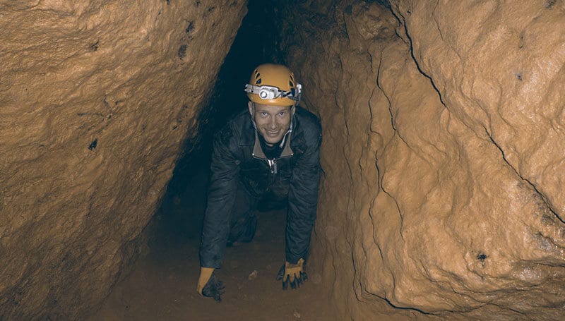 Heiko Gärtner schluft durch eine Höhle